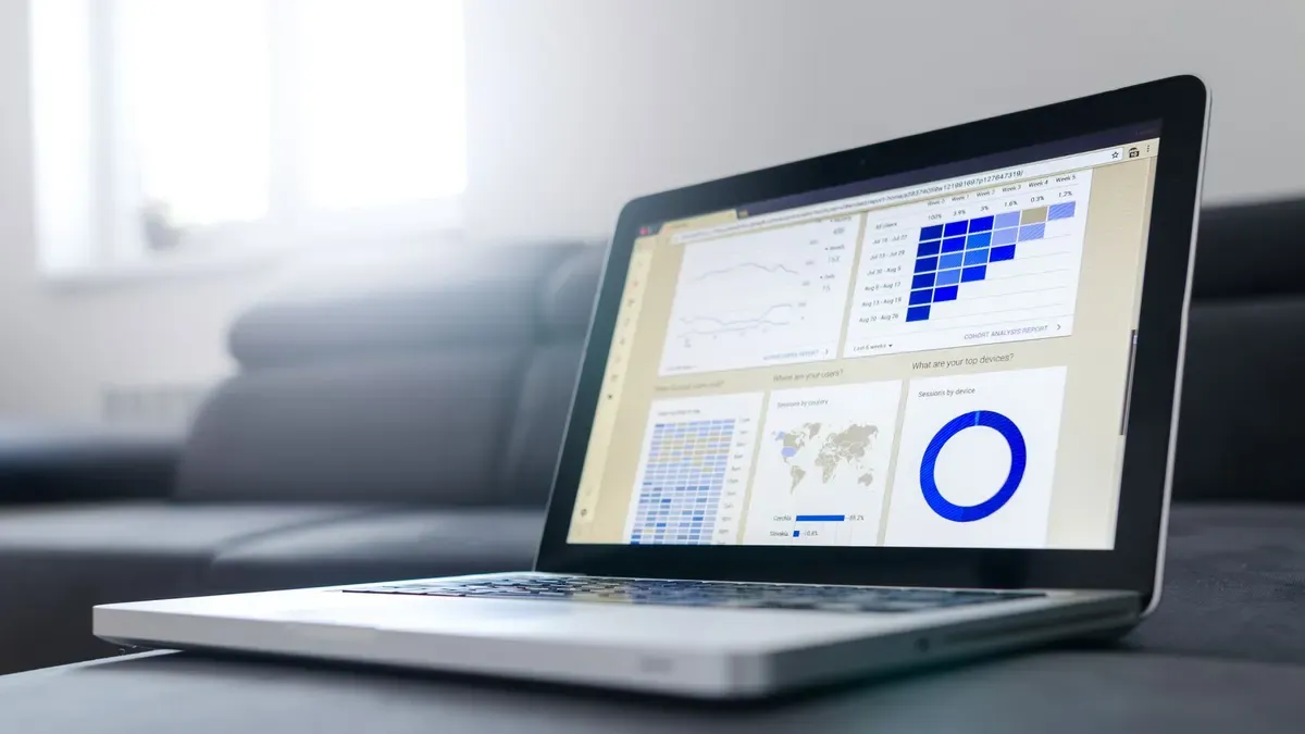 A laptop showing charts and graphs on a dashboard